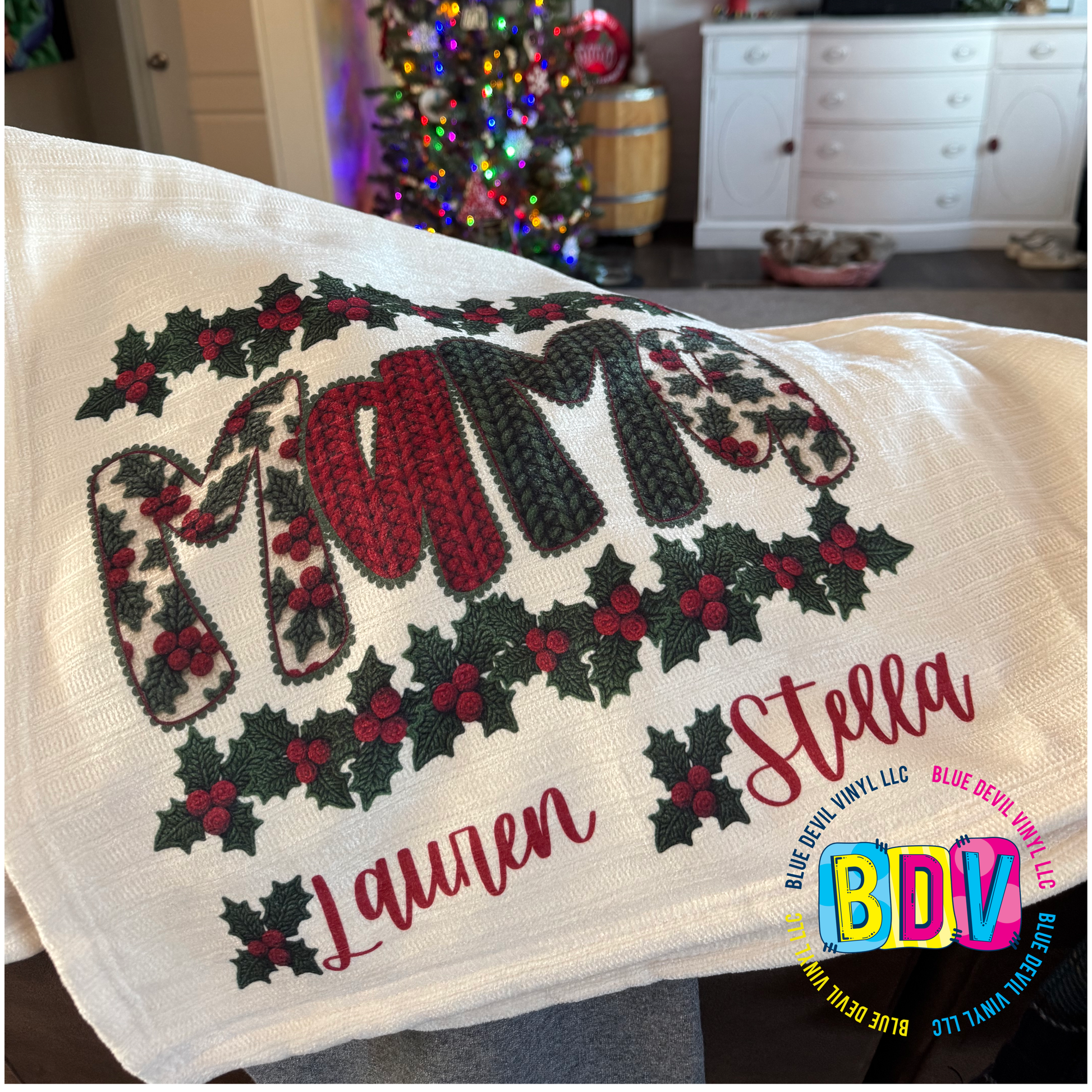 Decorative blanket with 'Mama' and holly design, featuring names 