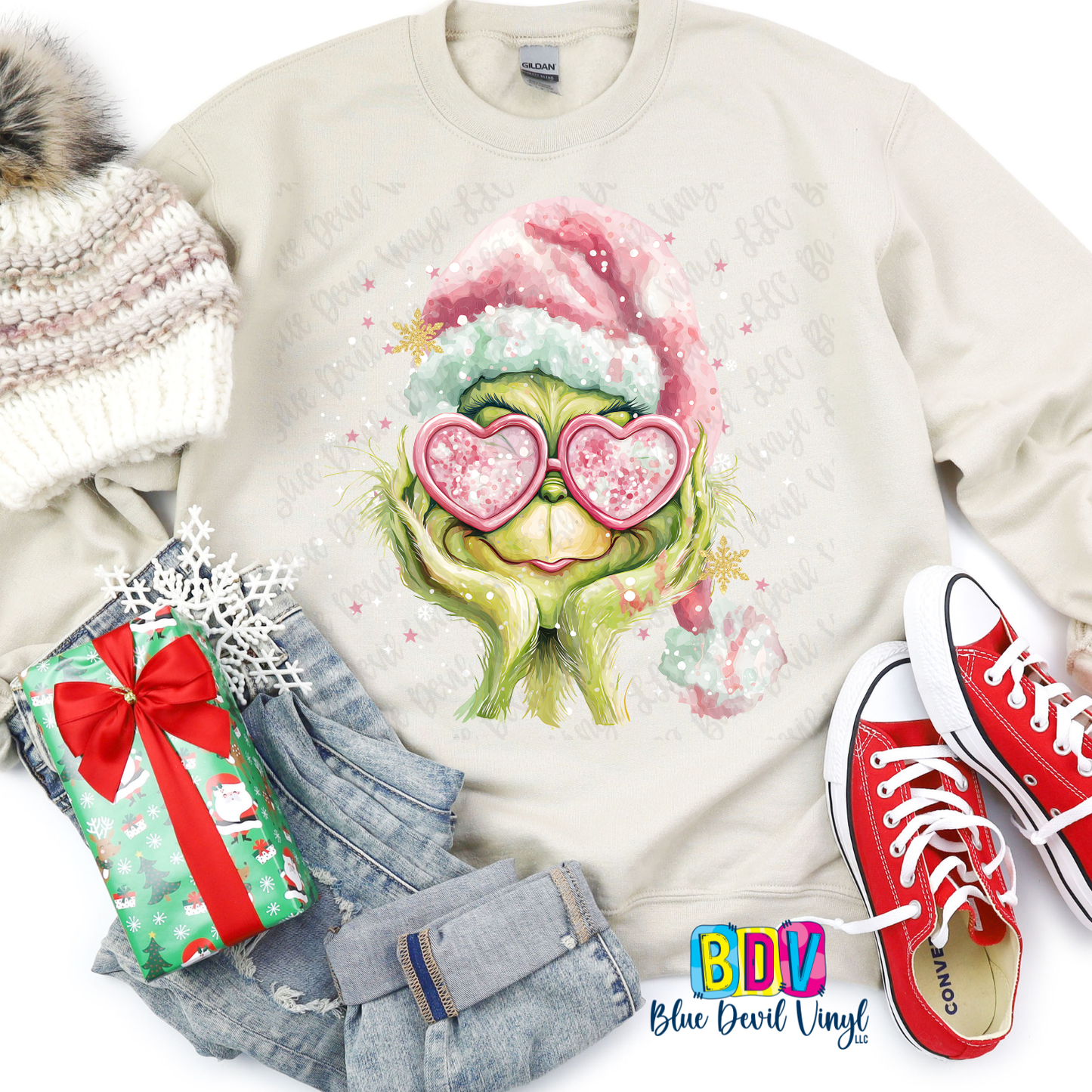 Sweatshirt with a festive design of a character wearing heart-shaped sunglasses, surrounded by Christmas-themed items.